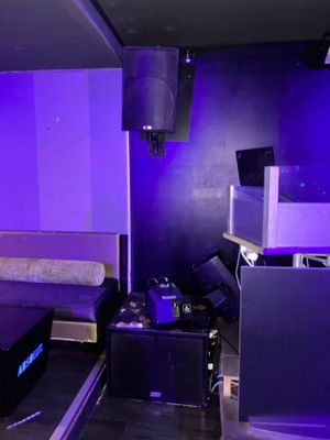 un lit et une télévision dans une pièce baignée d'une lumière violette