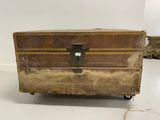 an old trunk sitting on wheels in a room