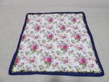 a close up of a blanket on a bed with a blue border