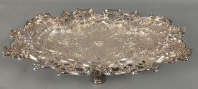 une assiette en argent ornée d'un motif décoratif sur un fond gris
