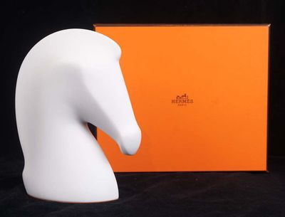 une statue représentant une tête de cheval blanc, à côté d'une boîte orange