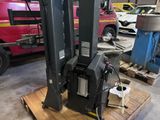a close up of a forklift in a warehouse with a truck in the background