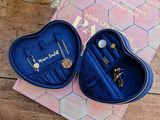 a pair of blue heart shaped jewelry boxes sitting on top of a wooden table