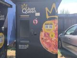 two vending machines in front of a building that has pizzas on it