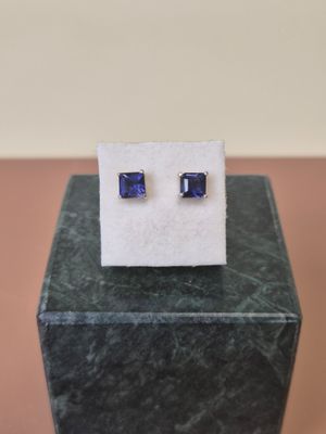 a pair of blue sapphire stud earrings on a marble block
