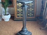 a black pedestal with a birdbath on top of it