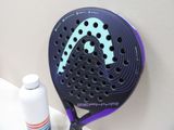 a tennis racquet and a bottle of water on a table