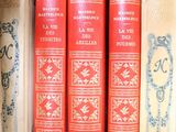 several old books are stacked on top of each other on a shelf