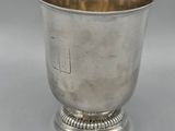 an antique silver cup with a raised rim and a raised base