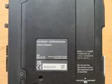 a close up of a black electronic device on a wooden surface
