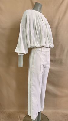 the mannequin is wearing white pants and a white top