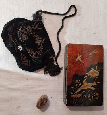 un petit sac à main et un petit livre posés sur une table