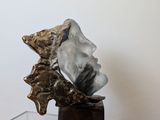 a glass table with a metal sculpture on top of it