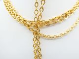a gold necklace with a cross on it on a mannequin