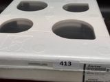 a white box with four holes in it on a table