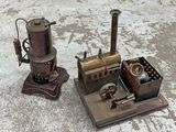 an old fashioned steam engine sitting on the ground next to an old fashioned machine