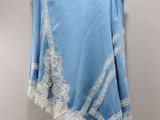a blue skirt with white lace on it hanging on a hanger