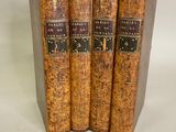 three old books sitting on top of each other on a white surface