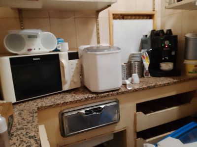 une petite cuisine équipée d'un micro-ondes, d'un grille-pain, d'un grille-pain et d'autres appareils électroménagers
