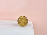 a gold coin sitting on top of a marble block