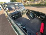a green truck with a black bed in the back of it