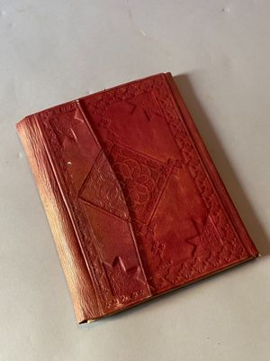 un vieux livre rouge à la couverture en cuir posé sur une table