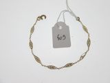 un gros plan d'un bracelet à chaîne en or sur lequel est accrochée une étiquette de prix