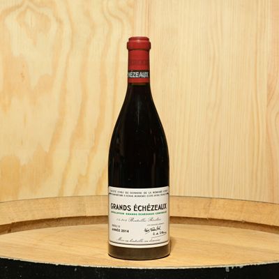 a bottle of wine sitting on top of a barrel
