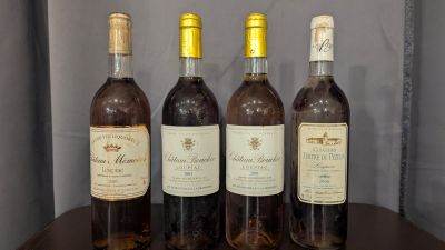 three bottles of wine sit on a table in front of a wall