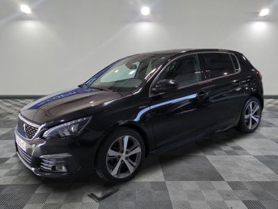 a black car is parked on a checkered floor in a garage