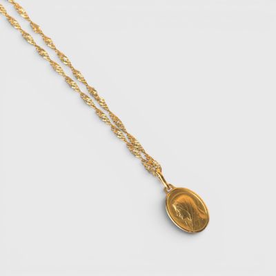 un collier en or avec une pièce suspendue à une chaîne en or