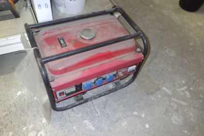 un petit générateur portable posé par terre dans un garage