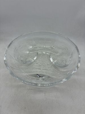 un saladier en verre posé sur une table, sur fond blanc