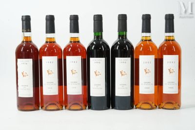six bouteilles de vin sont alignées sur une surface blanche