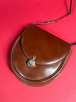 leather purse on a red surface with a chain around it