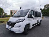 une photo d'un camping-car blanc garé sur un parking