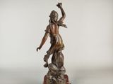 an image of a bronze statue of a woman on a rock