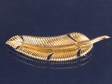 une broche en feuille d'or sur un fond noir