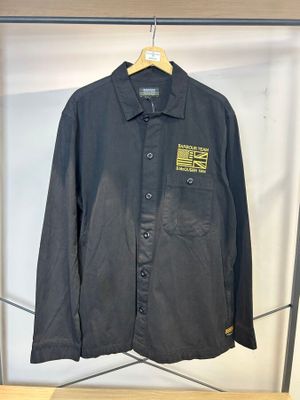 une veste de travail noire suspendue à un cintre dans un magasin de vêtements