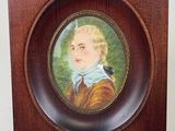a picture of a miniature picture of a boy in a wood frame
