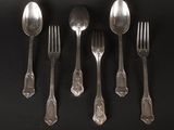 five silver spoons and two silver spoons on a black table