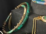 many different bracelets and necklaces sitting on a table