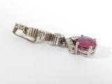 a close up of a pink stone and diamond broochle on a white background