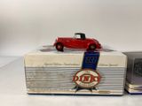 an old model of a red car sitting on top of a box