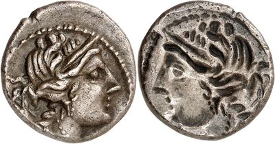 a silver coin with a head of a woman and a snake
