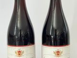 deux bouteilles de vin rouge posées l'une à côté de l'autre sur une surface blanche