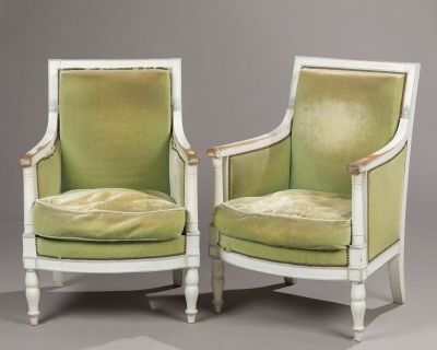 pair of green velveted chairs with white legs and arms