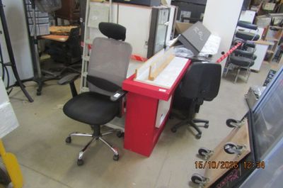un bureau avec un ordinateur et une chaise dans une pièce