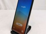 a close up of a phone on a stand on a white surface