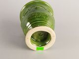 a green vase with a white rim and a green label on it